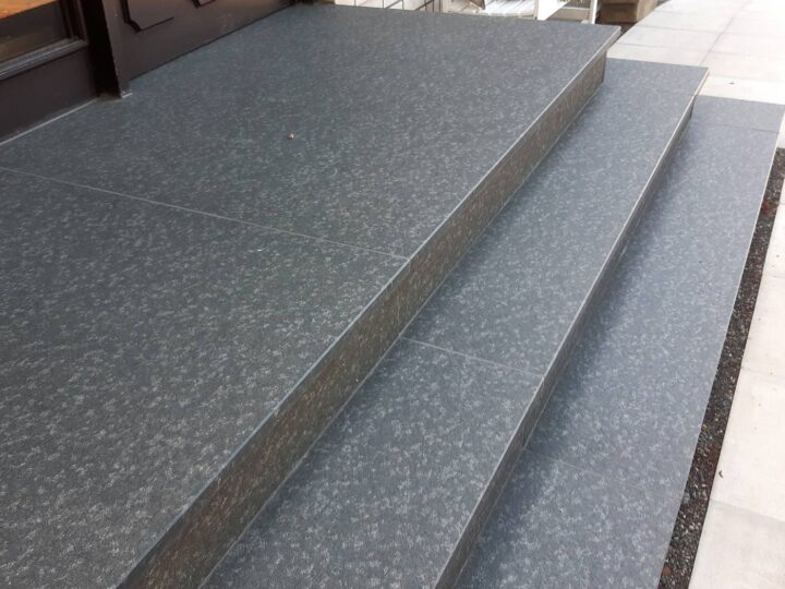 Eingangsstufen und Podest aus dunklem Granit vor einer Haustür
