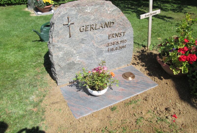 Grabstein in Felsenform mit Bronzeinschrift und Liegeplatte