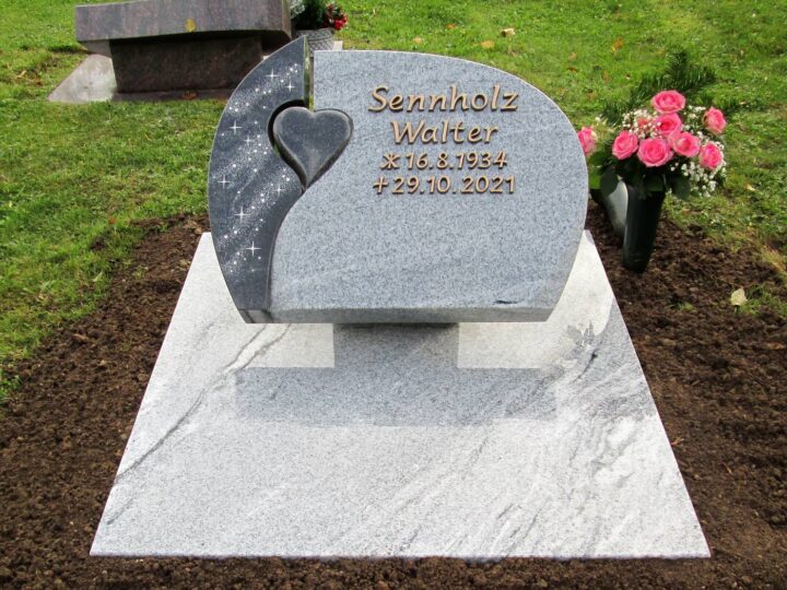 Grabmal Nr. 30: Grabstein aus hellem Granit mit eingelassenem Herz, Sternendekor und Bronzeschrift auf einer Liegeplatte
