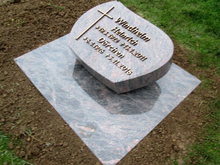 Grabmal Nr. 28: Liegender Grabstein mit Bronzekreuz und Bronzeschrift auf einer Sockelplatte aus Granit