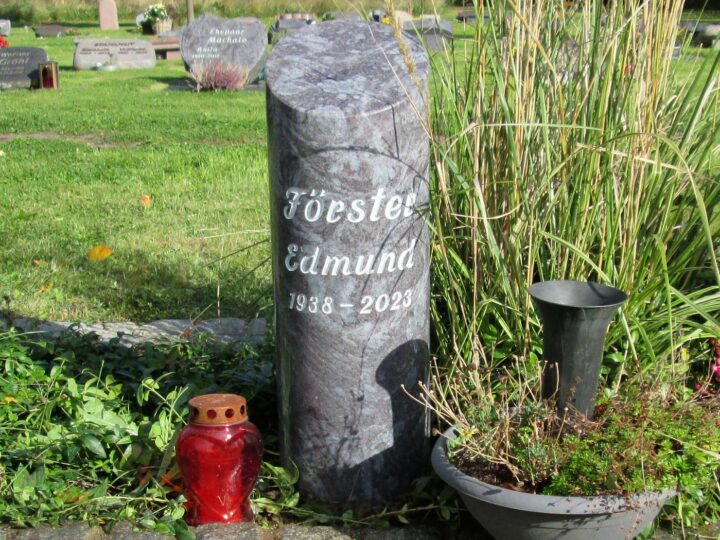 Grabmal Nr. 32: Runde Säulenstele aus grauem Granit mit eingearbeiteter Schrift