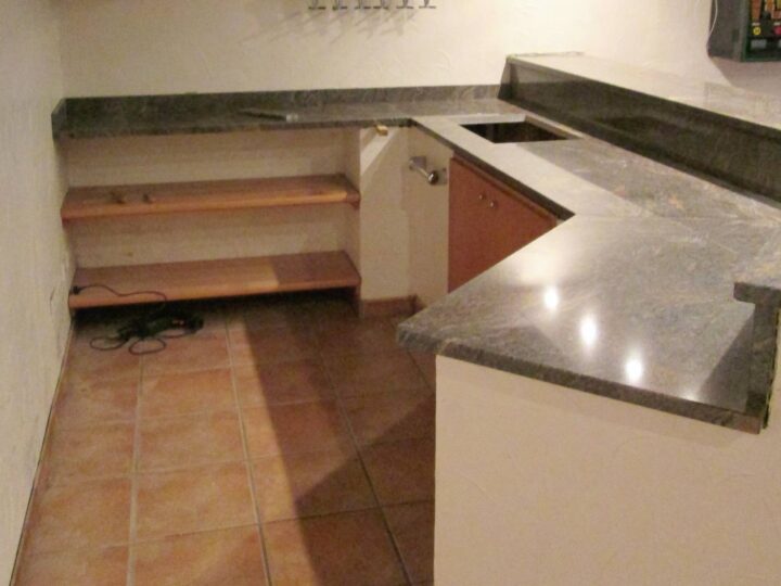 Theke mit Arbeitsplatte aus grünlich-grauem Naturstein in einem Partyraum