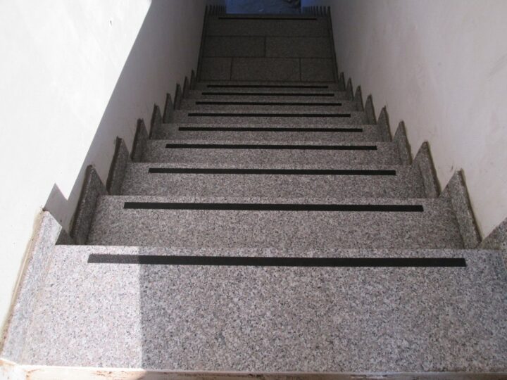 Treppenabgang mit Granitstufen und dunklen Rutschschutzstreifen